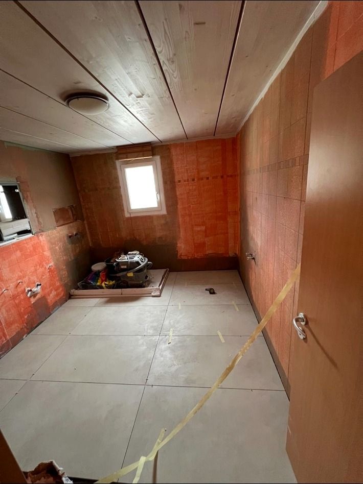 La salle de bain pendant les travaux, avec murs mis à nu, sol en cours de préparation et outillage de chantier