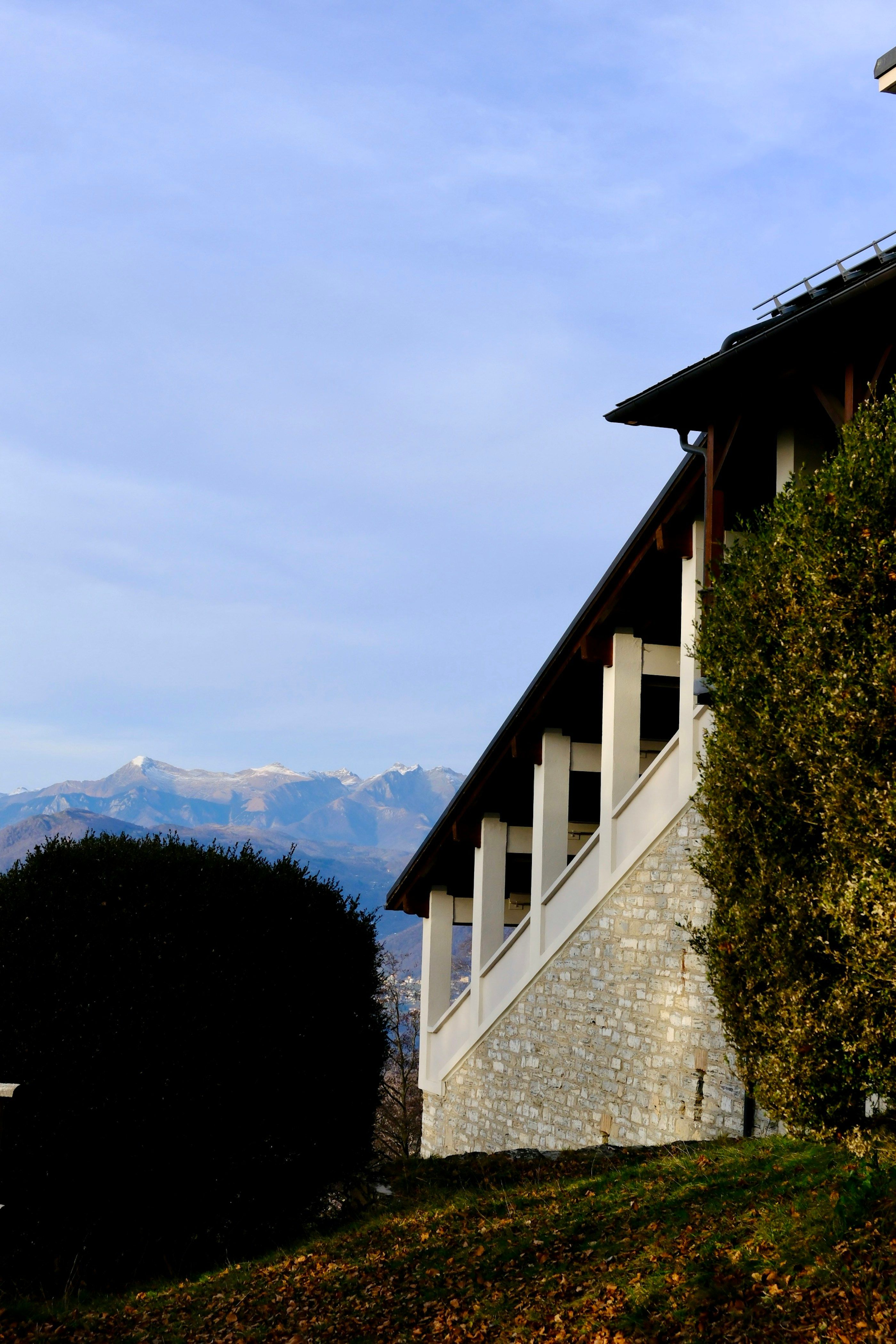 Bâtiment à façade de pierre sur les hauteurs de Lugano, face aux montagnes